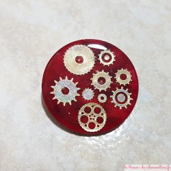 Broche baroque rougeet argent rouages et engrenages forme ronde aspect émail, fermeture sécurité