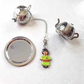 Boule à thé ou tisane forme théière en acier inoxydable avec un décor personnalisé d'une poupée japonaise vert anis