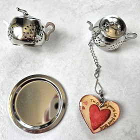Boule à thé ou tisane forme théière acier inoxydable avec un décor  coeur et mention gravée "tu es toujours la plus belle".