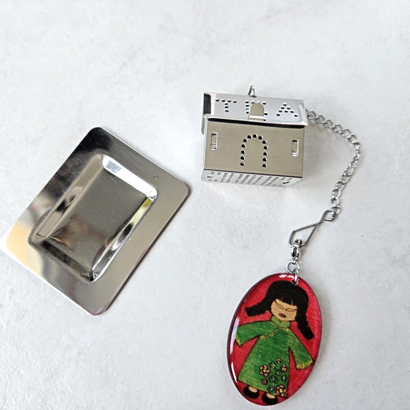 Boule à thé ou tisane acier inoxydable forme maison avec un décor de poupée chinoise