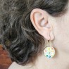 boucle d'oreille fantaisie dissociée ronde sur dormeuse habille le visage