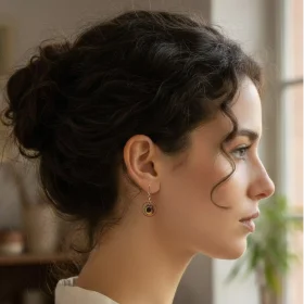 Boucle d'oreille artisanale asymétrique et biface métallisé doré et orangé doré coté oreille gauche