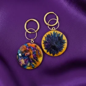 Réalisées avec deux faces distinctes, ces boucles d'oreilles asymétriques dévoilent leurs nuances de couleurs.